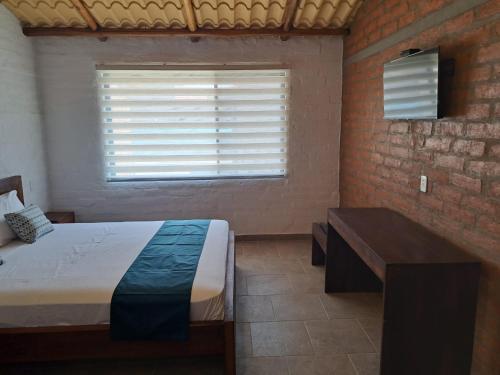 a bedroom with a bed and a window and a desk at PUNTA COCO VILLAS BEACH in Cojimíes