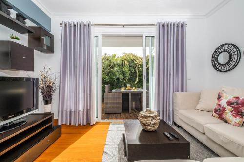 a living room with a couch and a tv at Home to Stay by Homie in Funchal