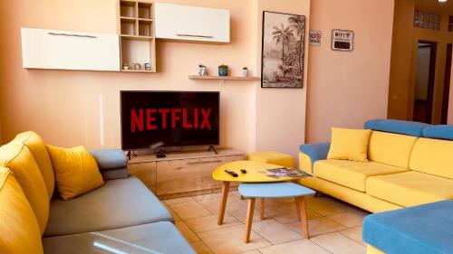 a living room with a couch and a tv at Jessie's apartments in Durrës