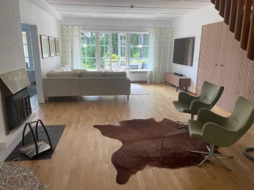 sala de estar con sofá, sillas y chimenea en Beach House Ängelholm, en Ängelholm