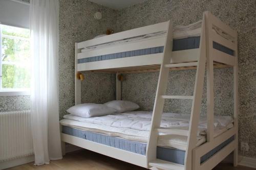 a white bunk bed in a room with a window at Beach House Ängelholm in Ängelholm