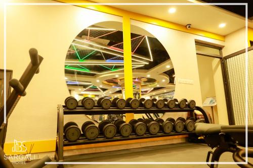 a gym with a rack of dumbbells on a wall at Sargali Duhok Hotel in Duhok
