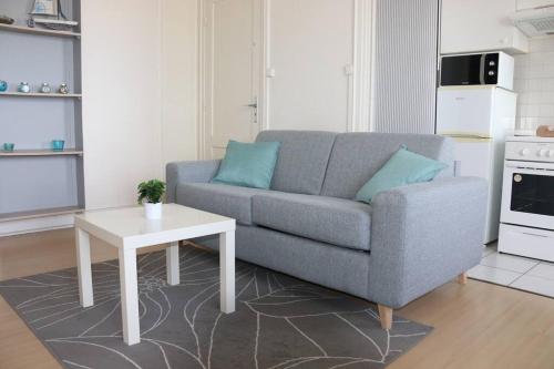 ein Wohnzimmer mit einem Sofa und einem Tisch in der Unterkunft Escapade vue sur mer in Dunkerque