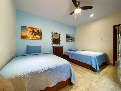 una camera con 2 letti e un ventilatore a soffitto di CASA AROMA DE MAR a Isla Mujeres