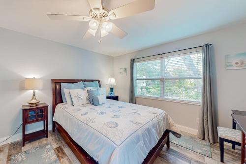 a bedroom with a bed with a ceiling fan and a window at The Harbour Home in St. Augustine