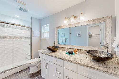 a bathroom with two sinks and a toilet and a mirror at The Harbour Home in St. Augustine