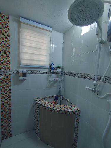 ein Bad mit einer Dusche mit einem Waschbecken und einem Fenster in der Unterkunft Tasek Homestay D Village Ipoh in Ipoh
