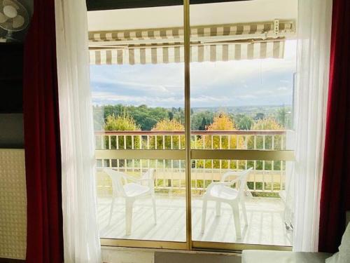 ventana con vistas a un balcón con sillas blancas en Logement meublé près de Beauval, en Montrichard