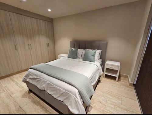 um quarto com uma cama grande e almofadas azuis em Penhouse vista al mar y ciudad na Cidade do Panamá