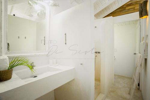 ein weißes Badezimmer mit einem Waschbecken und einem Spiegel in der Unterkunft non disponible in Las Terrenas