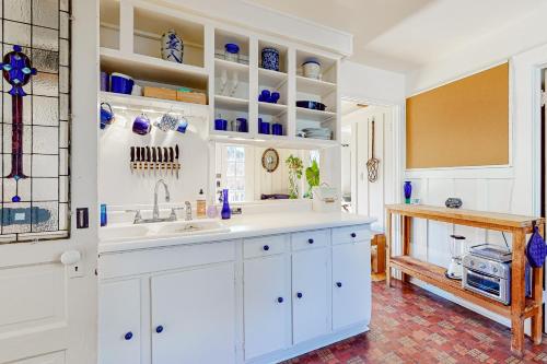 una cocina con armarios blancos y fregadero en Hygge House, en Berkeley