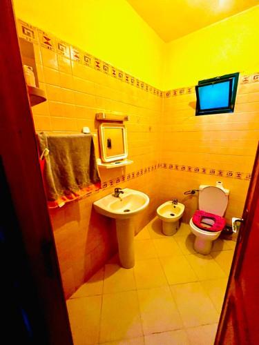 La salle de bains jaune est pourvue de toilettes et d'un lavabo. dans l'établissement Tanger tanja tanja morocco, à Tanger