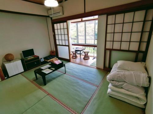 Takachiho B&B Ukigumo في تاكاتشيهو: غرفة فيها سرير وطاولة فيها