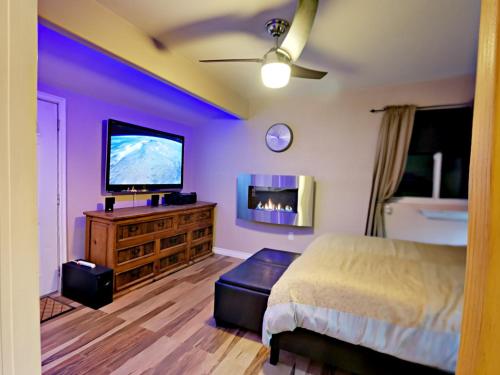 Luxury Tiny House في سان دييغو: غرفة نوم بسرير وتلفزيون بشاشة مسطحة