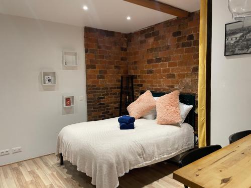 a bedroom with a bed with a brick wall at Superbe Studio Montmartre, rue des Abbesses in Paris