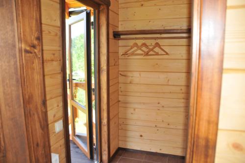 a room with a wooden wall and a closet with hangers at Kozichky Guest House in Tatariv