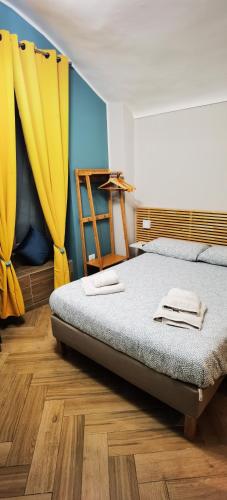 a bedroom with a bed with yellow curtains at Trebis in Naples