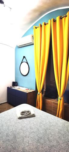 a bedroom with a bed with yellow curtains at Trebis in Naples
