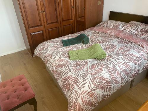 a bed with two green pillows on it at A nice double size bedroom in Mottingham in Eltham