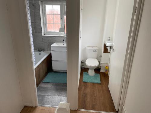 a bathroom with a toilet and a tub and a sink at A nice double size bedroom in Mottingham in Eltham