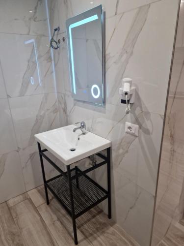a bathroom with a sink and a mirror at Joanna Suites in Sarandë