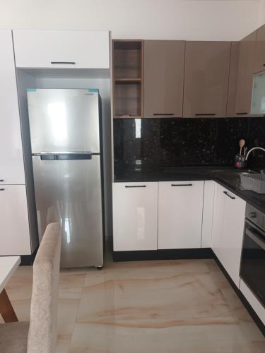 a kitchen with white cabinets and a stainless steel refrigerator at Dar NZ in La Marsa