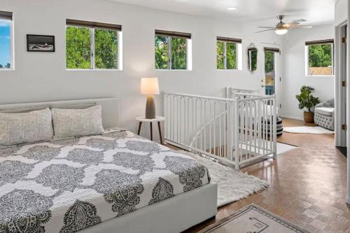 een witte slaapkamer met een bed en ramen bij Amethyst Retreat. Back Yard with Hot Tub & Views! in Sedona