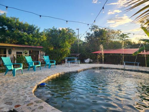 a swimming pool in a yard with chairs and a house at Cabañas VILLA PAOLA in Rivera