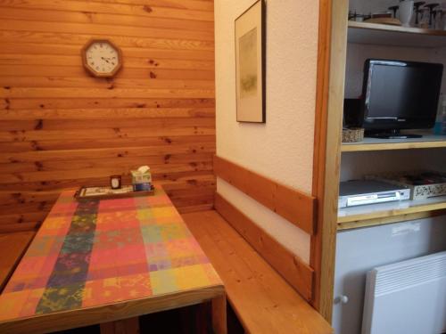 une chambre avec une table et une horloge sur un mur dans l'établissement Appartement avec parking, près des pistes - FR-1-181-2728, à La Plagne Tarentaise