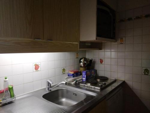 une cuisine avec un évier et un plan de travail dans l'établissement Appartement avec parking, près des pistes - FR-1-181-2728, à La Plagne Tarentaise