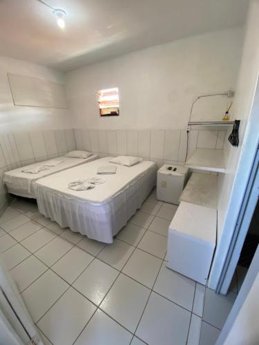 2 camas en una habitación con suelo de baldosa blanca en Pousada Estrela Do Mar, en Maragogi
