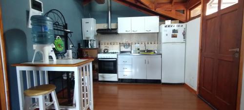 een keuken met witte apparatuur en een houten vloer bij Departamento Ushuaia in Ushuaia