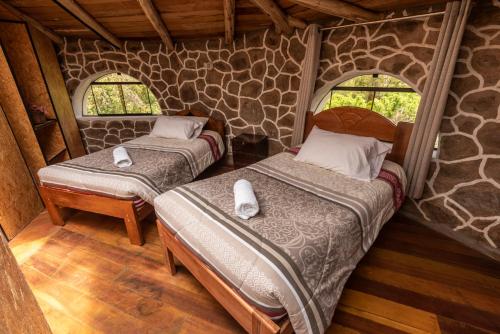 2 camas en una habitación con 2 ventanas en Bungalow RURU WASI en Urubamba
