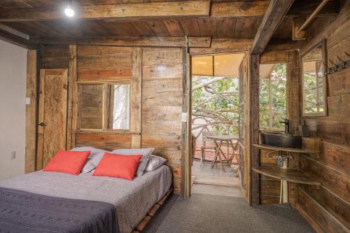 a bedroom with a bed in a room with wooden walls at El Refugio de Sayulita - Health and Wellness House in Sayulita