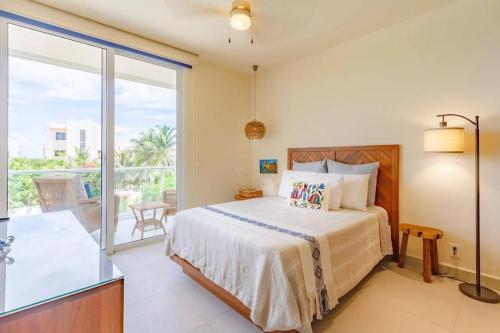 a bedroom with a bed and a balcony at Tortuga Azul Private Terrace Rooftop Pool W BBQ Beach Access 11 Pools Free Beach Club in Akumal