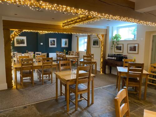 a restaurant with wooden tables and chairs and lights at The Temple Bar Inn in Hereford