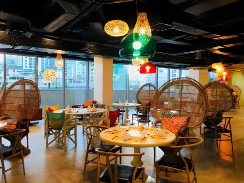 een restaurant met tafels en stoelen en kroonluchters bij DFT Apartment "Rockwell View" Host By HomeStay in Manilla