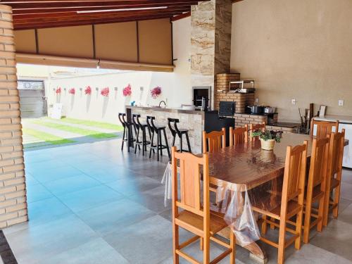 a kitchen and dining room with a wooden table and chairs at Império D in Tanabi