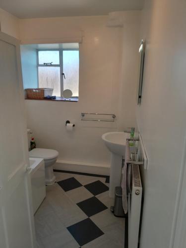 a bathroom with a sink and a toilet at Mews Cottage, a 2 bedroom Georgian Cottage which comfortably sleeps 4 located in a quiet courtyard in the centre of Olney in Olney