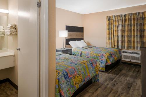 a hotel room with two beds and a window at Knights Inn Grand Rapids East Airport in East Grand Rapids