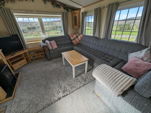 - un salon avec un canapé et une table dans l'établissement Attymchugh Lodge, 