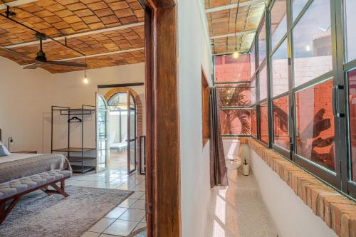 a room with a bed and some windows at El Refugio de Sayulita - Solo Adultos in Sayulita