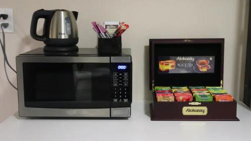 a microwave and a coffee pot on top of a counter at Riaz's Peaceful Mississauga Home in Mississauga