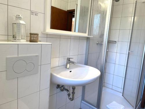 y baño blanco con lavabo y ducha. en Haus-Dallacker-Fewo-Nr-2, en Cuxhaven