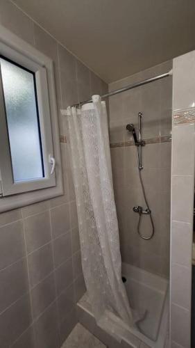 une salle de bain avec une douche avec un rideau de douche dans l'établissement Appartement chaleureux, proche de la gare, à Perpignan