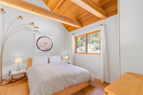 un dormitorio con una cama y una ventana en Wildwood - Modern 2 BR with Private Hot tub Walk to North Tahoe Regional Park, en Tahoe Vista
