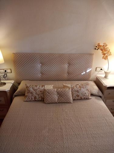 una camera da letto con un grande letto con cuscini sopra di El paraíso del sol a Cartagena