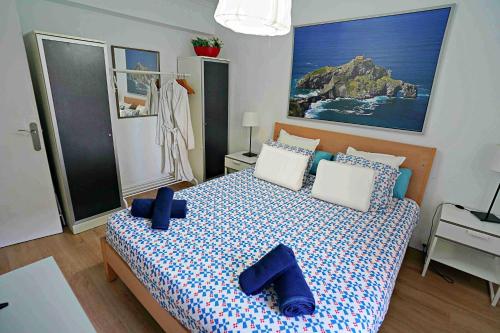 a bedroom with a large bed with blue pillows at Apart 2 terrazas para 4 personas Bilbao centro in Bilbao