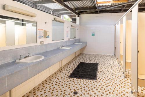 a bathroom with two sinks and two mirrors at BIG4 Townsville Gateway Holiday Park in Townsville