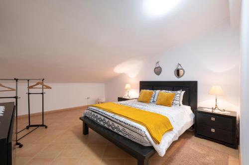a bedroom with a bed with a yellow blanket at Sara House in Ponta do Sol